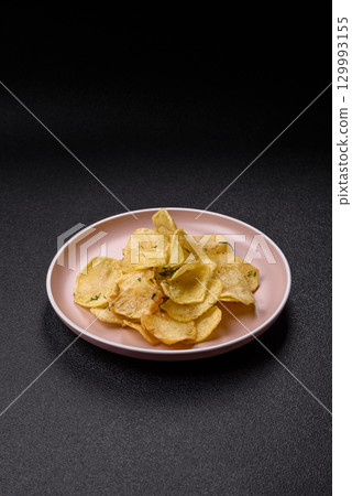 Crisps fried with salt, spices and garlic. Cooked potatoes Crisps fried with salt, spices and garlic. Cooked potatoes 129993155