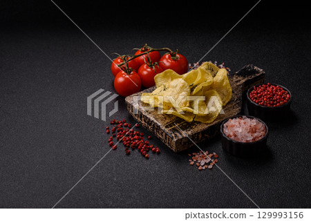 Crisps fried with salt, spices and garlic. Cooked potatoes 129993156