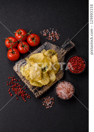 Crisps fried with salt, spices and garlic. Cooked potatoes 129993158