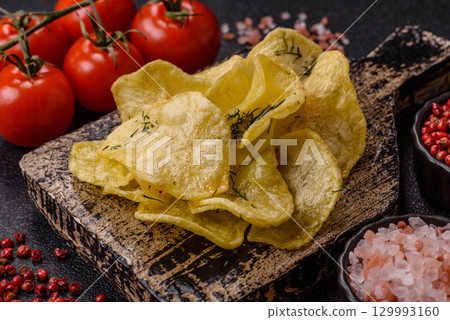 Crisps fried with salt, spices and garlic. Cooked potatoes 129993160