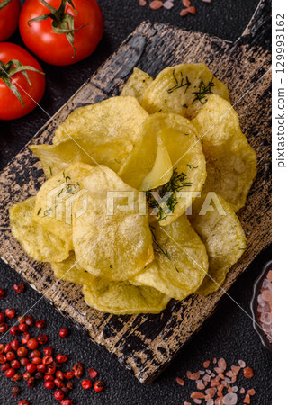 Crisps fried with salt, spices and garlic. Cooked potatoes Crisps fried with salt, spices and garlic. Cooked potatoes 129993162