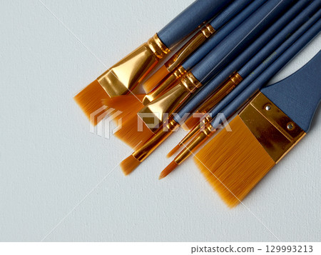 Assorted Artist Paintbrushes on a Canvas Surface for Creative Artistic Projects 129993213