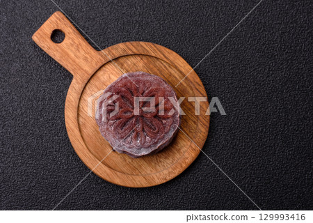 Chinese mooncake is an Asian sweet dessert. Asian mooncake as a background for your design 129993416