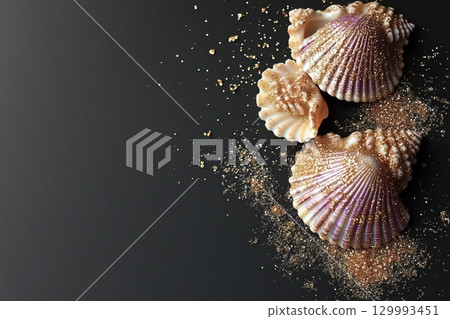 Flat lay of iridescent seashells on black velvet with scattered golden sand Flat lay of iridescent seashells on black velvet with scattered golden sand 129993451