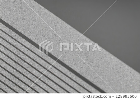 Geometric shadow play on minimalist white wall from blinds abstract architectural composition 129993606