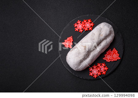 Christmas Stollen, a German sweet cake with marzipan and fruit. Winter Christmas Stollen Christmas Stollen, a German sweet cake with marzipan and fruit. Winter Christmas Stollen 129994098