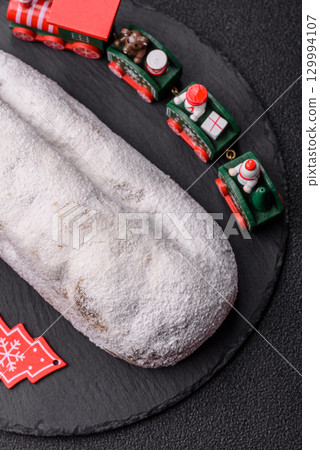 Christmas Stollen, a German sweet cake with marzipan and fruit. Winter Christmas Stollen Christmas Stollen, a German sweet cake with marzipan and fruit. Winter Christmas Stollen 129994107