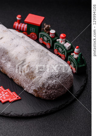 Christmas Stollen, a German sweet cake with marzipan and fruit. Winter Christmas Stollen Christmas Stollen, a German sweet cake with marzipan and fruit. Winter Christmas Stollen 129994108