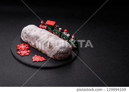 Christmas Stollen, a German sweet cake with marzipan and fruit. Winter Christmas Stollen Christmas Stollen, a German sweet cake with marzipan and fruit. Winter Christmas Stollen 129994109