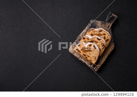 Christmas Stollen, a German sweet cake with marzipan and fruit. Winter Christmas Stollen Christmas Stollen, a German sweet cake with marzipan and fruit. Winter Christmas Stollen 129994128