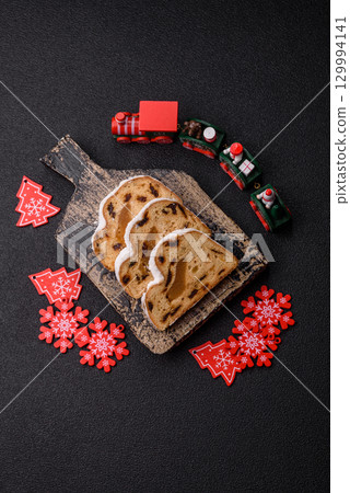 Christmas Stollen, a German sweet cake with marzipan and fruit. Winter Christmas Stollen Christmas Stollen, a German sweet cake with marzipan and fruit. Winter Christmas Stollen 129994141