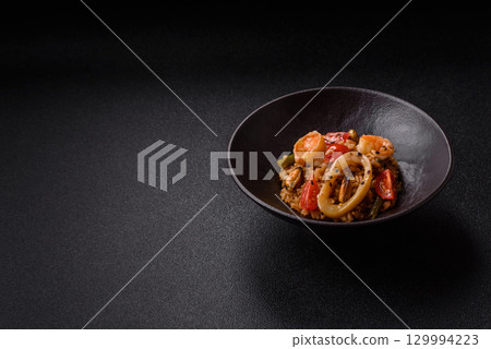 Rice and prawns or paella, a meal with seafood and vegetables. Cooked rice with shrimp 129994223