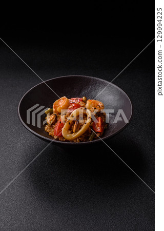 Rice and prawns or paella, a meal with seafood and vegetables. Cooked rice with shrimp 129994225