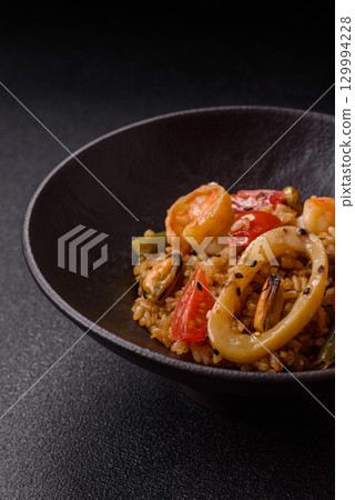Rice and prawns or paella, a meal with seafood and vegetables. Cooked rice with shrimp 129994228