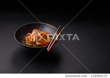 Rice and prawns or paella, a meal with seafood and vegetables. Cooked rice with shrimp 129994233