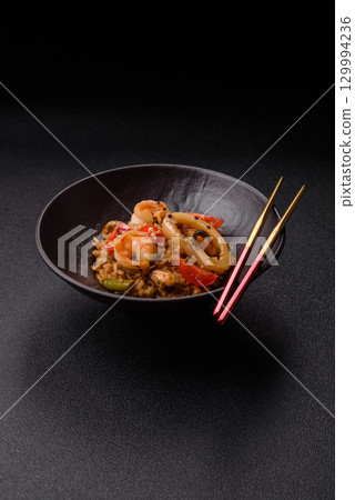 Rice and prawns or paella, a meal with seafood and vegetables. Cooked rice with shrimp 129994236
