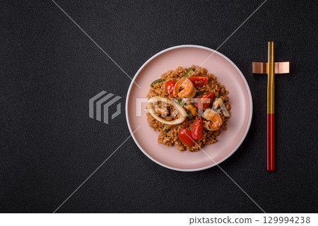 Rice and prawns or paella, a meal with seafood and vegetables. Cooked rice with shrimp 129994238