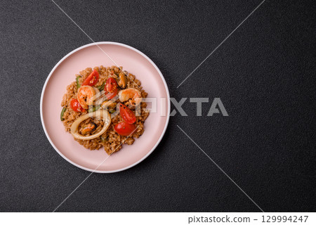 Rice and prawns or paella, a meal with seafood and vegetables. Cooked rice with shrimp 129994247