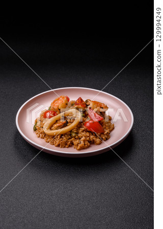 Rice and prawns or paella, a meal with seafood and vegetables. Cooked rice with shrimp Rice and prawns or paella, a meal with seafood and vegetables. Cooked rice with shrimp 129994249