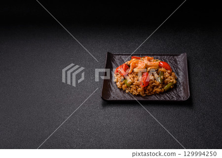 Rice and prawns or paella, a meal with seafood and vegetables. Cooked rice with shrimp 129994250