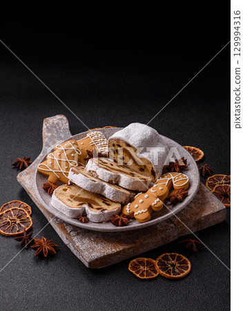 Christmas Stollen, a German sweet cake with marzipan and fruit. Winter Christmas Stollen Christmas Stollen, a German sweet cake with marzipan and fruit. Winter Christmas Stollen 129994316