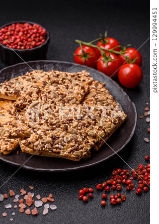 Crispbread, thin bread with seeds and grains, a baked cracker. Crispbread with sesame seeds 129994451