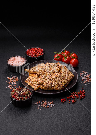 Crispbread, thin bread with seeds and grains, a baked cracker. Crispbread with sesame seeds 129994455