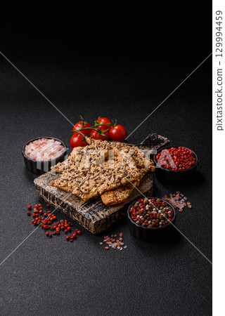 Crispbread, thin bread with seeds and grains, a baked cracker. Crispbread with sesame seeds Crispbread, thin bread with seeds and grains, a baked cracker. Crispbread with sesame seeds 129994459