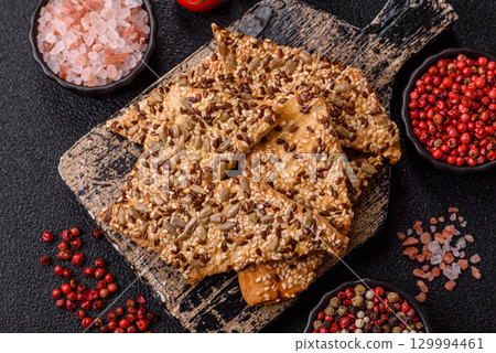 Crispbread, thin bread with seeds and grains, a baked cracker. Crispbread with sesame seeds Crispbread, thin bread with seeds and grains, a baked cracker. Crispbread with sesame seeds 129994461
