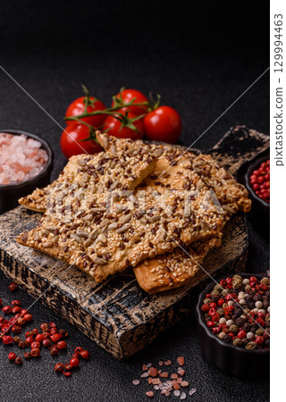 Crispbread, thin bread with seeds and grains, a baked cracker. Crispbread with sesame seeds Crispbread, thin bread with seeds and grains, a baked cracker. Crispbread with sesame seeds 129994463