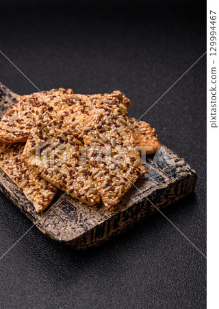 Crispbread, thin bread with seeds and grains, a baked cracker. Crispbread with sesame seeds Crispbread, thin bread with seeds and grains, a baked cracker. Crispbread with sesame seeds 129994467