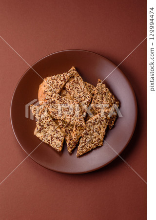 Crispbread, thin bread with seeds and grains, a baked cracker. Crispbread with sesame seeds 129994474
