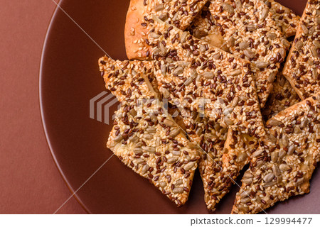 Crispbread, thin bread with seeds and grains, a baked cracker. Crispbread with sesame seeds Crispbread, thin bread with seeds and grains, a baked cracker. Crispbread with sesame seeds 129994477