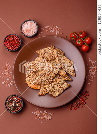 Crispbread, thin bread with seeds and grains, a baked cracker. Crispbread with sesame seeds Crispbread, thin bread with seeds and grains, a baked cracker. Crispbread with sesame seeds 129994485