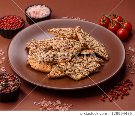 Crispbread, thin bread with seeds and grains, a baked cracker. Crispbread with sesame seeds 129994486