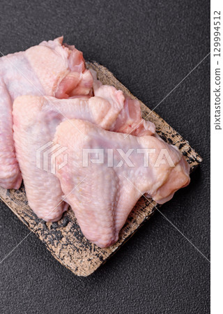 Raw chicken wings, fresh uncooked poultry meat. Chicken or turkey wings Raw chicken wings, fresh uncooked poultry meat. Chicken or turkey wings 129994512