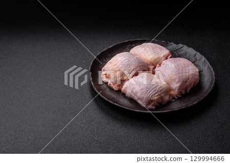Meat, raw chicken thigh, leg in skin with salt and spices. Raw chicken thigh Meat, raw chicken thigh, leg in skin with salt and spices. Raw chicken thigh 129994666