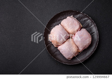 Meat, raw chicken thigh, leg in skin with salt and spices. Raw chicken thigh Meat, raw chicken thigh, leg in skin with salt and spices. Raw chicken thigh 129994667