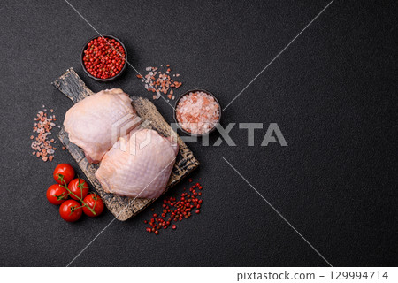 Meat, raw chicken thigh, leg in skin with salt and spices. Raw chicken thigh Meat, raw chicken thigh, leg in skin with salt and spices. Raw chicken thigh 129994714
