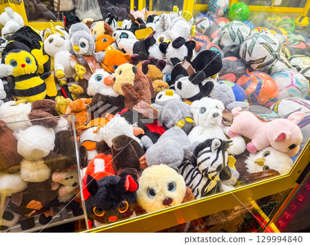 Stuffed toys inside a claw machine. Childhood, leisure, play and amusement in an arcade entertainment setting. Stuffed toys inside a claw machine. Childhood, leisure, play and amusement in an arcade entertainment setting. 129994840