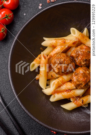 Penne pasta with meatballs in tomato sauce with salt and spices. Italian food penne pasta Penne pasta with meatballs in tomato sauce with salt and spices. Italian food penne pasta 129995229