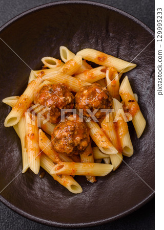 Penne pasta with meatballs in tomato sauce with salt and spices. Italian food penne pasta Penne pasta with meatballs in tomato sauce with salt and spices. Italian food penne pasta 129995233