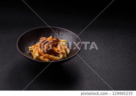 Penne pasta with meatballs in tomato sauce with salt and spices. Italian food penne pasta Penne pasta with meatballs in tomato sauce with salt and spices. Italian food penne pasta 129995235