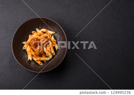 Penne pasta with meatballs in tomato sauce with salt and spices. Italian food penne pasta Penne pasta with meatballs in tomato sauce with salt and spices. Italian food penne pasta 129995236