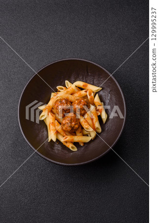 Penne pasta with meatballs in tomato sauce with salt and spices. Italian food penne pasta Penne pasta with meatballs in tomato sauce with salt and spices. Italian food penne pasta 129995237