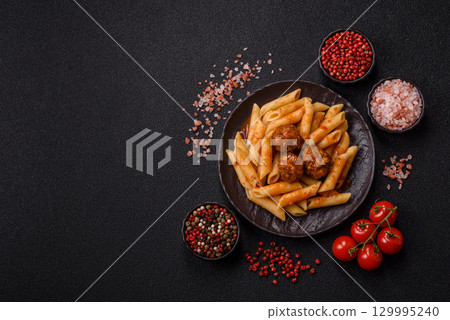 Penne pasta with meatballs in tomato sauce with salt and spices. Italian food penne pasta 129995240