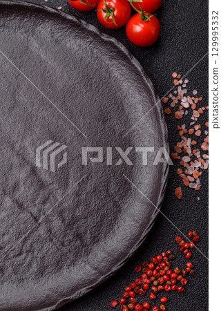 Empty round black plate for food, risotto or pasta. Empty plate on dark background Empty round black plate for food, risotto or pasta. Empty plate on dark background 129995332