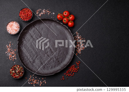 Empty round black plate for food, risotto or pasta. Empty plate on dark background Empty round black plate for food, risotto or pasta. Empty plate on dark background 129995335