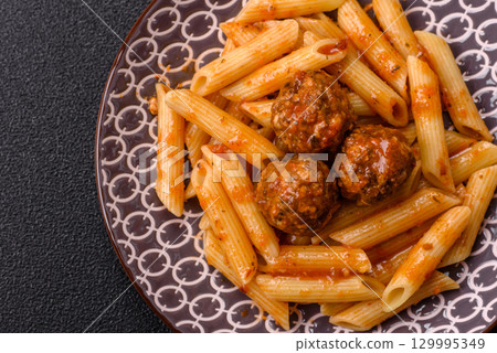 Penne pasta with meatballs in tomato sauce with salt and spices. Italian food penne pasta Penne pasta with meatballs in tomato sauce with salt and spices. Italian food penne pasta 129995349