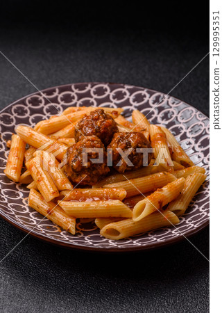 Penne pasta with meatballs in tomato sauce with salt and spices. Italian food penne pasta Penne pasta with meatballs in tomato sauce with salt and spices. Italian food penne pasta 129995351